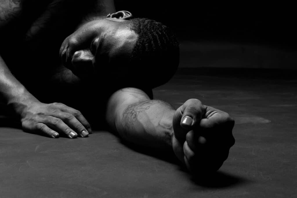 a man laying on the ground because of muscle cramp